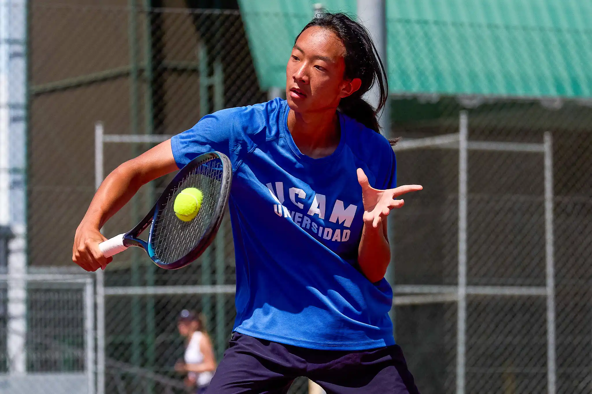 Jugador voleando tenis.
