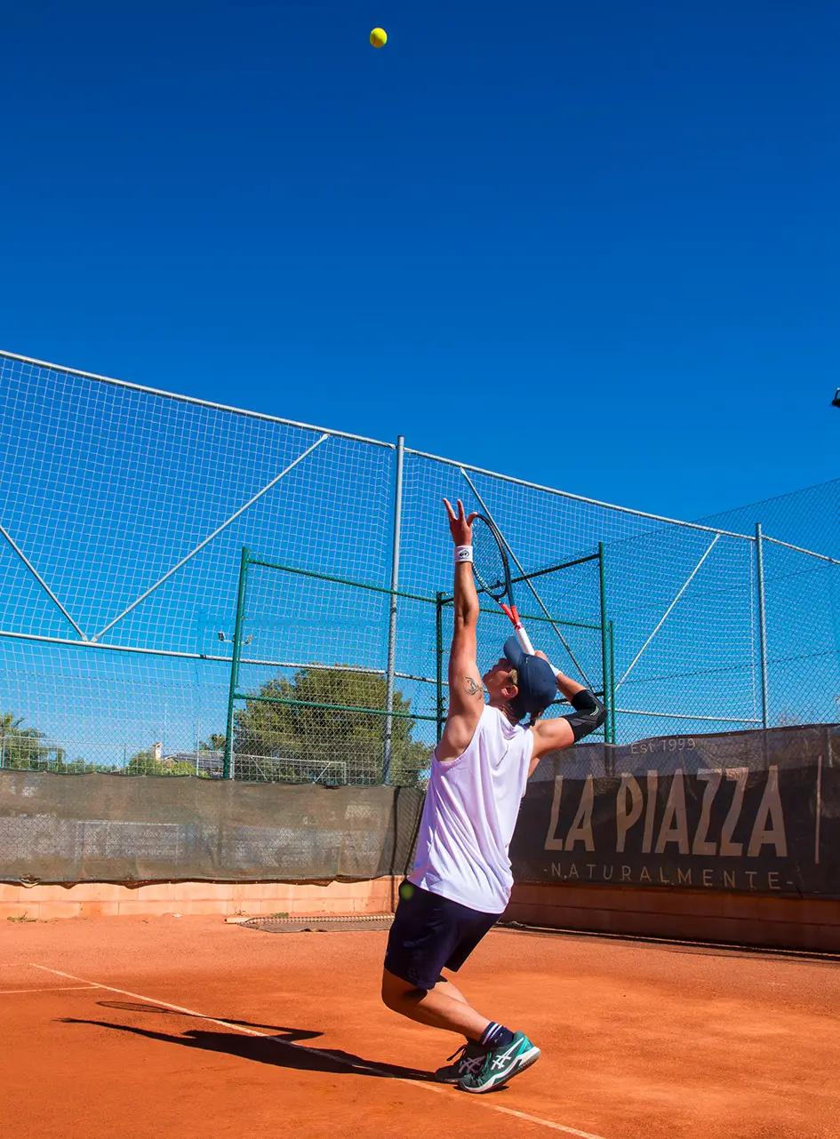 Saque de tenis, en tierra batida.